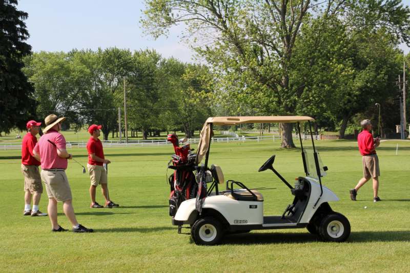 a group of people standing on a golf course
