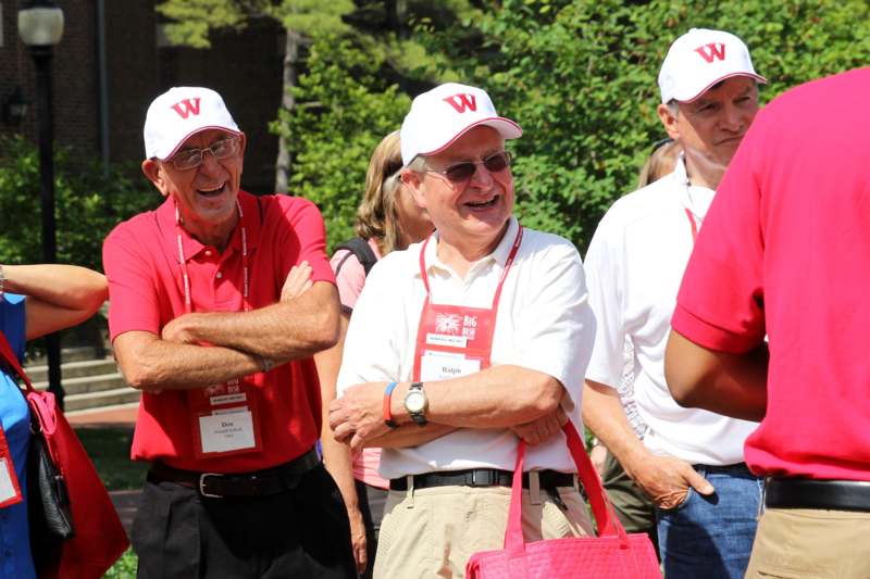 a group of men wearing white hats and red shirts