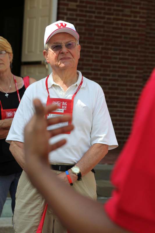 a man wearing a white hat and a red lanyard