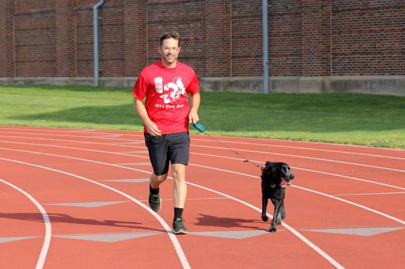 a man walking a dog on a track