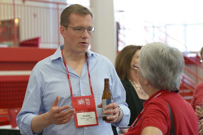a man holding a beer bottle and talking to a woman