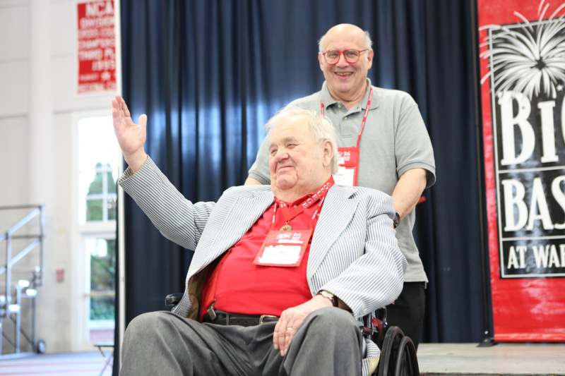 a man in a wheelchair waving