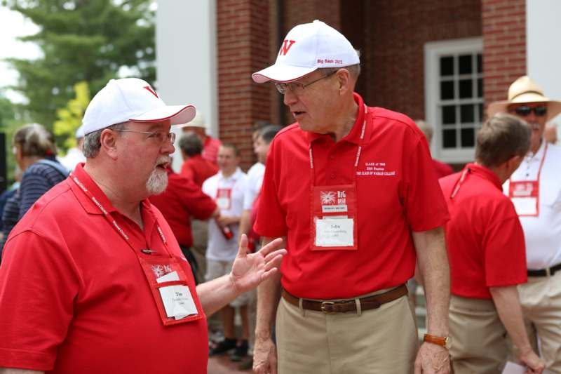 men wearing red shirts and white hats talking to each other