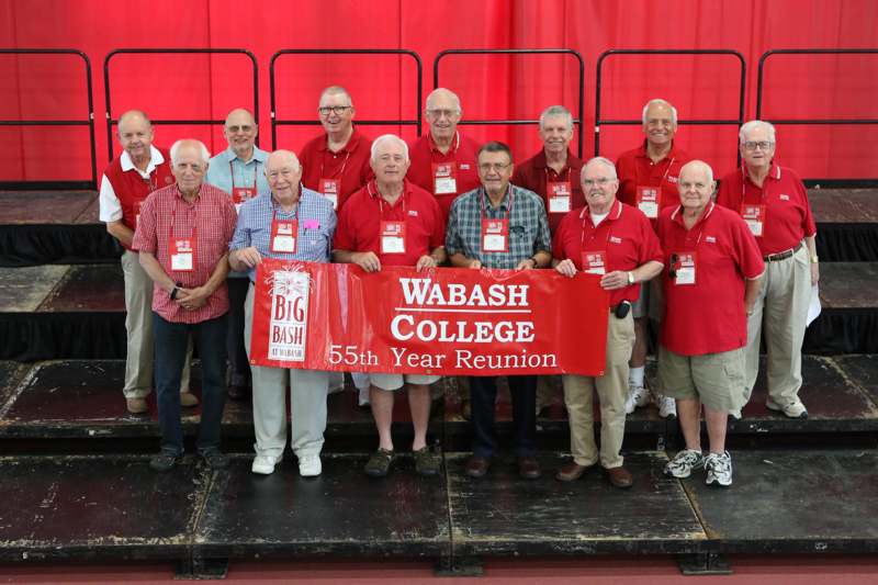 a group of men wearing matching red shirts and holding a banner