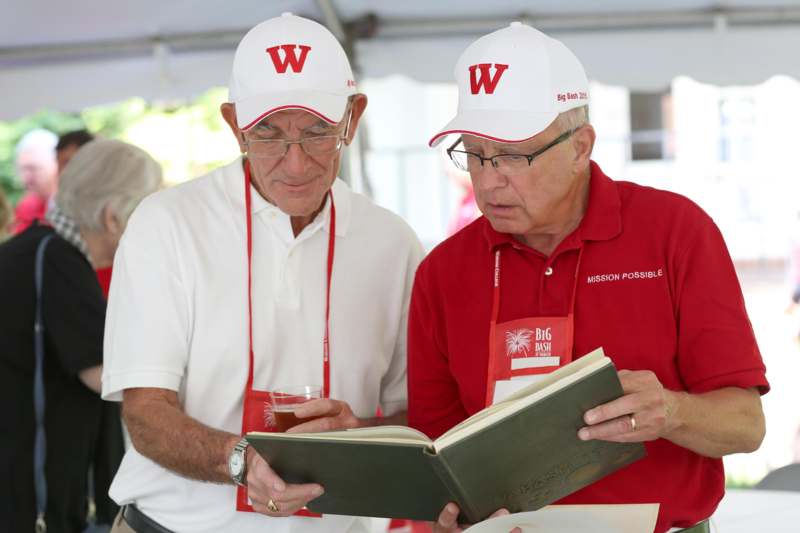a couple of men wearing white hats and holding a book