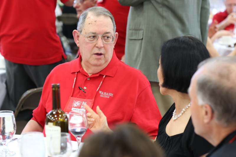 a man in a red shirt talking to a woman