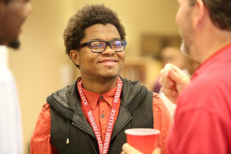 a man wearing glasses and a red lanyard