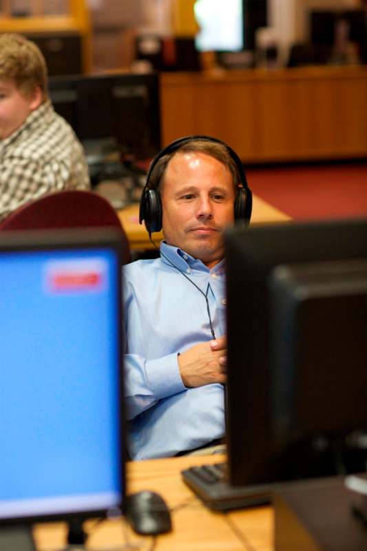 a man wearing headphones sitting at a desk