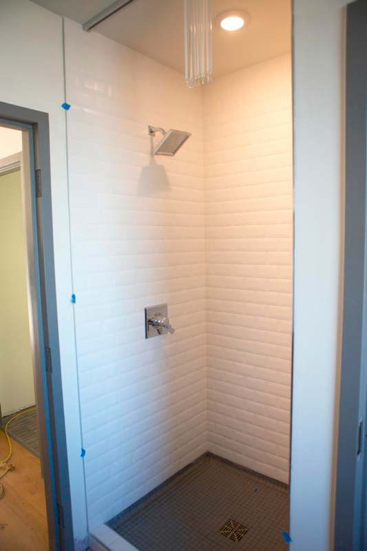 a shower with a tile wall