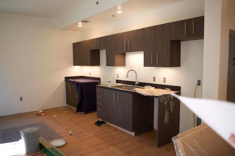 a kitchen with dark cabinets and a sink