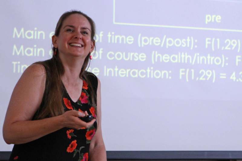 a woman smiling at a presentation