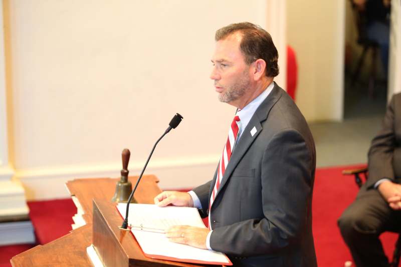a man in a suit and tie at a podium