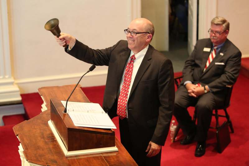 a man holding a bell up to his hand