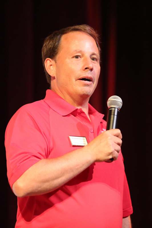a man in a red shirt holding a microphone