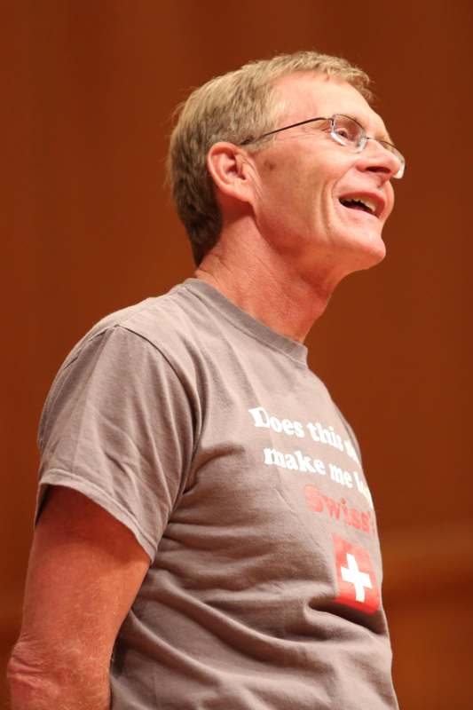 a man wearing glasses and a grey shirt