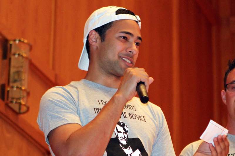 a man in a white hat holding a microphone