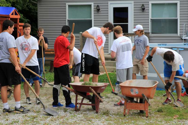 a group of people with shovels and wheelbarrows