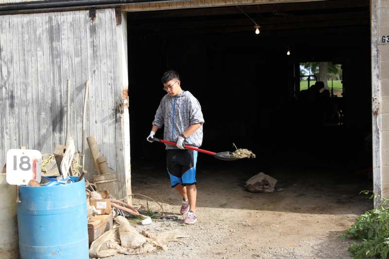 a man holding a shovel in a garage