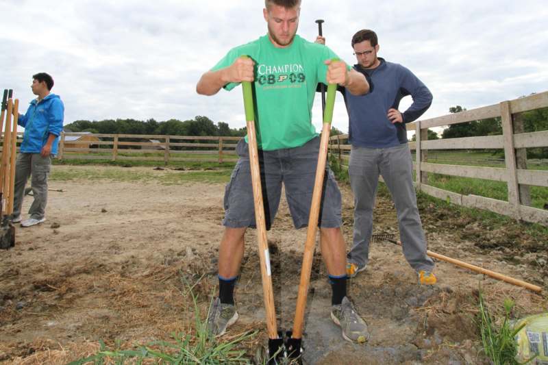 a man holding shovels in dirt