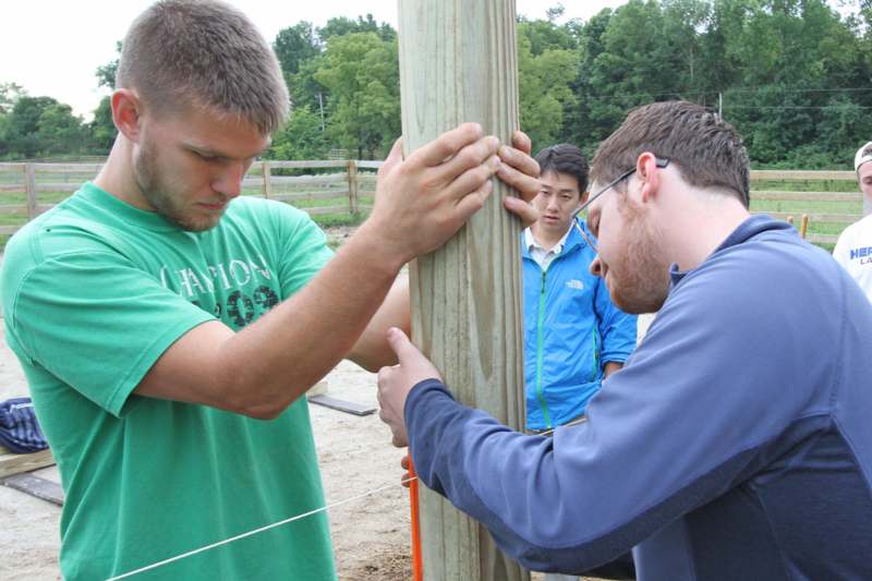 a group of men holding a wooden pole