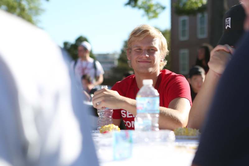 a man sitting at a table with water bottles and food