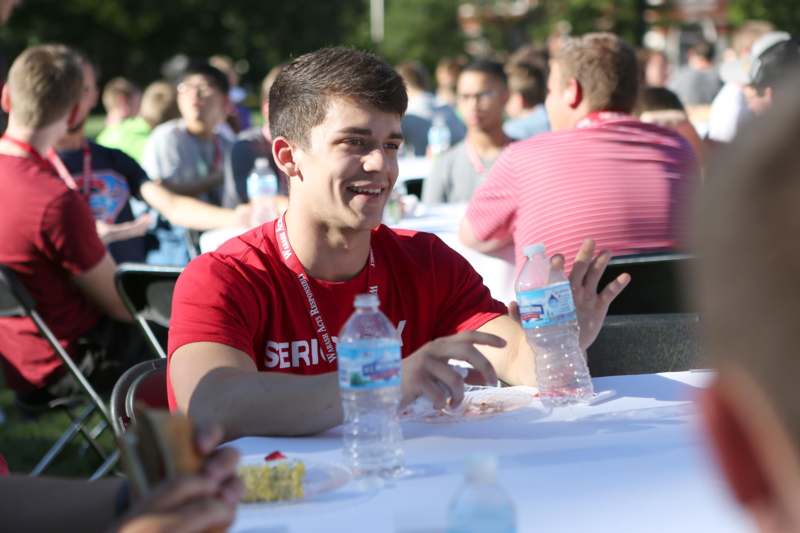 a man sitting at a table with water bottles and food