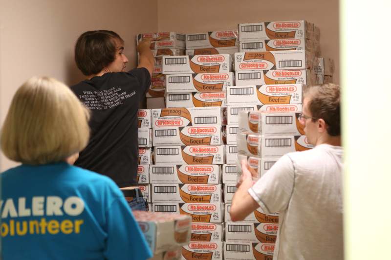a group of people standing in a room with boxes stacked on each other