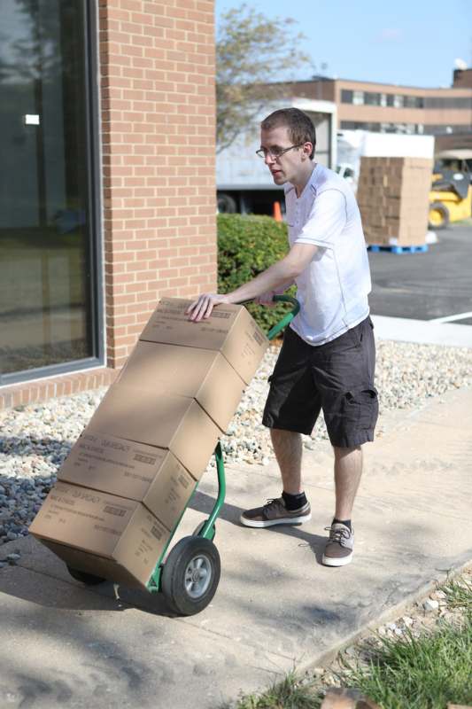 a man pushing a hand truck with boxes