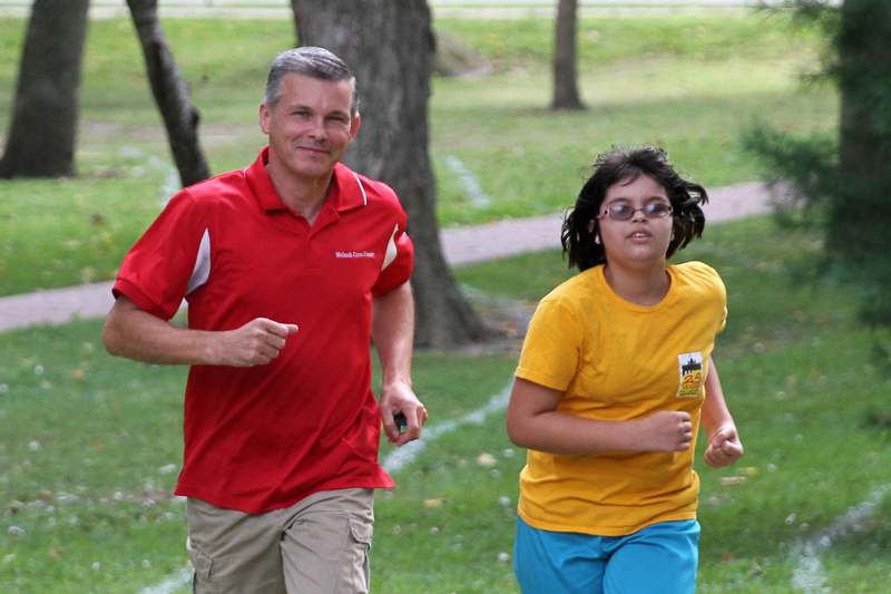 a man and girl running in a park