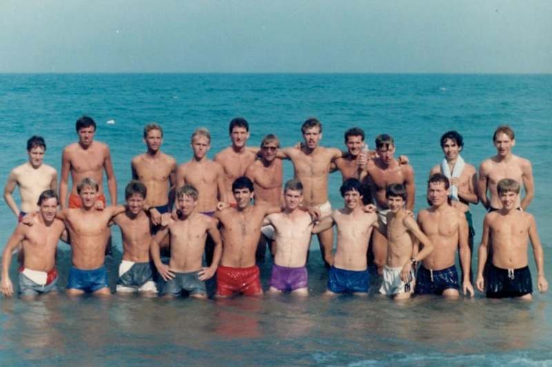 a group of men in swim trunks in the water