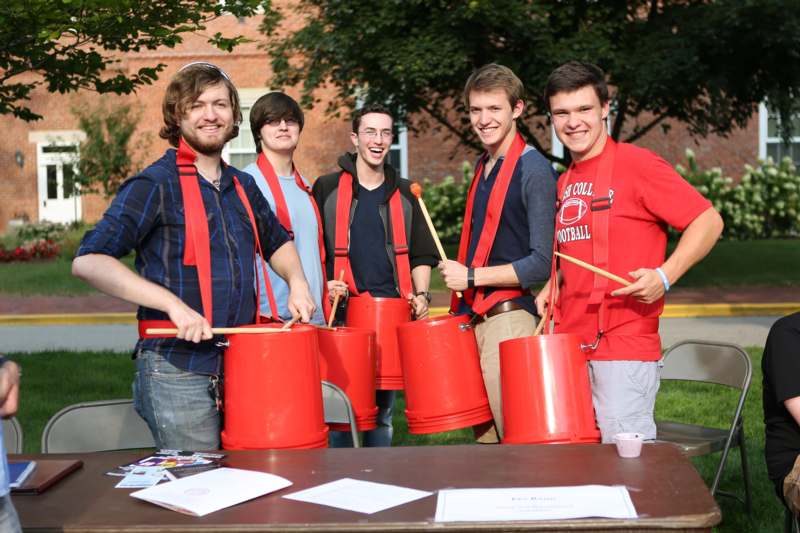 a group of men wearing red shirts and holding red buckets