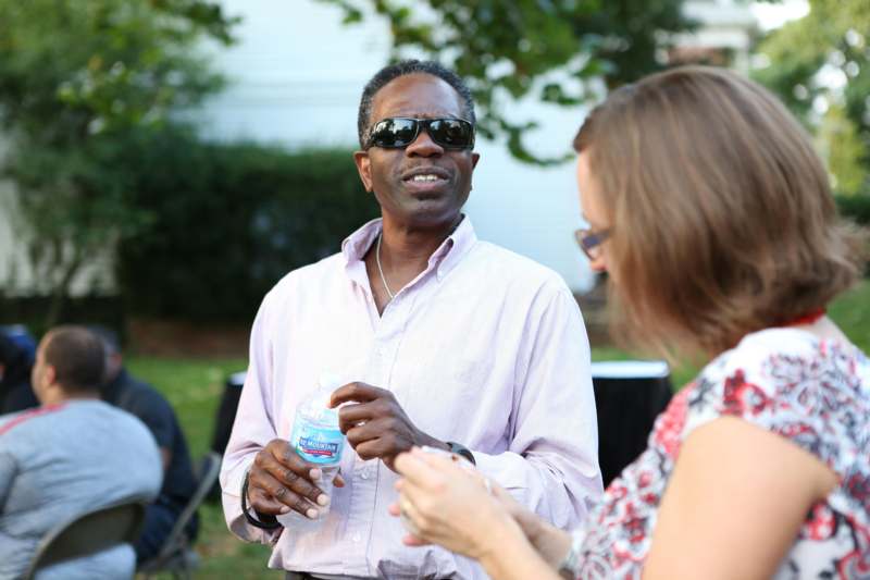 a man holding a bottle of water and a woman talking