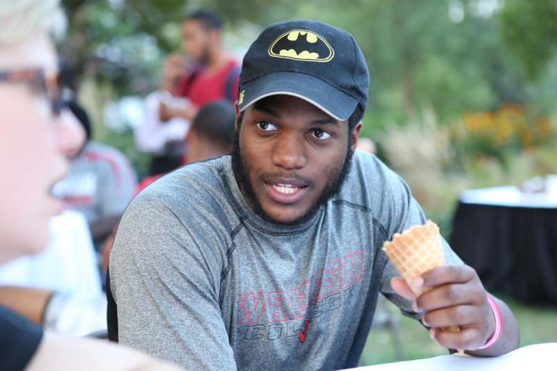 a man wearing a hat and holding an ice cream cone