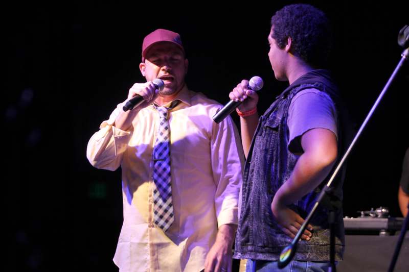 a man holding a microphone next to another man