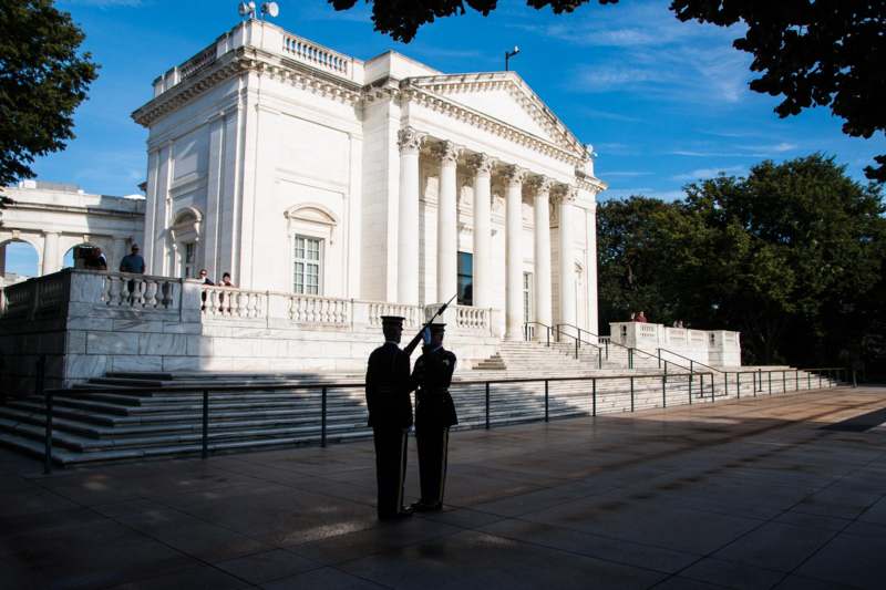 two men in uniform standing in front of a white building