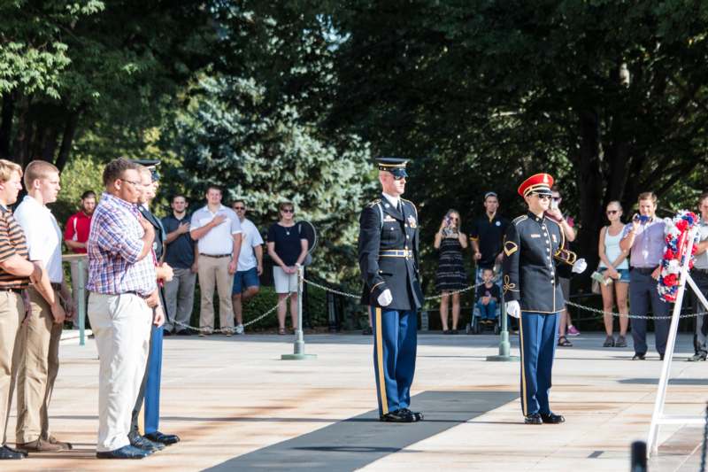 a group of people in uniform standing on a sidewalk