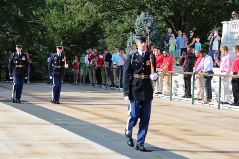 a group of people in uniform walking on a sidewalk
