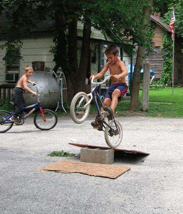 a boy jumping on a bicycle