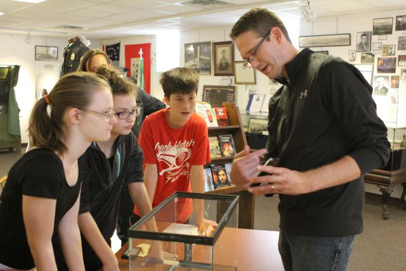 a man looking at a display case with a group of people