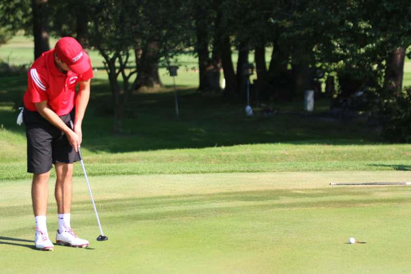 a man in a red shirt on a golf course