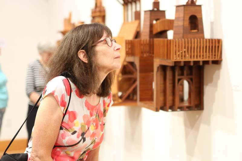 a woman looking at a model of a castle