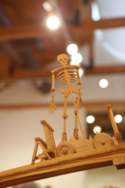 a wooden skeleton on top of a wooden cart