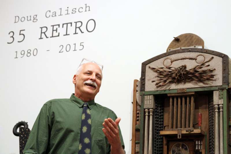 a man standing in front of an old mechanical device