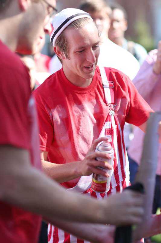 a man in red shirt holding a can