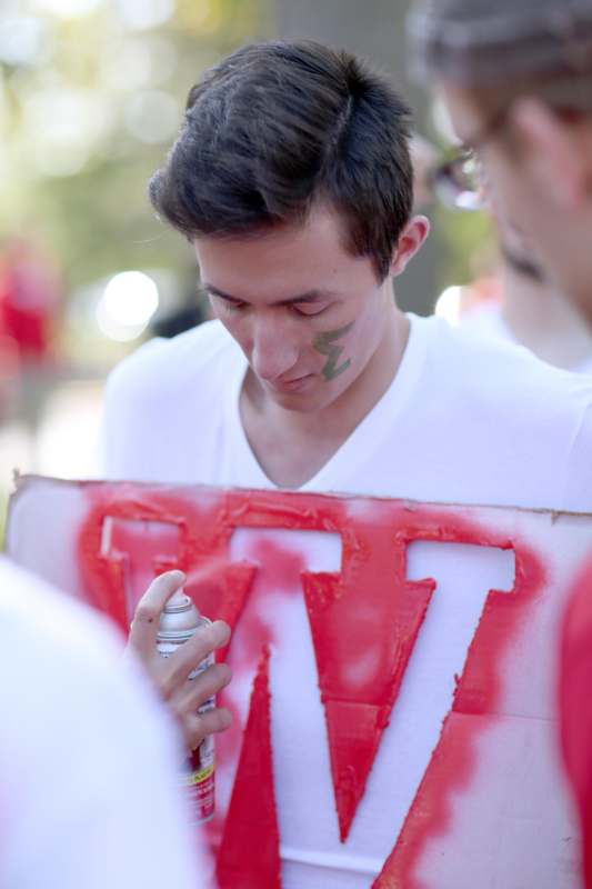 a man holding a sign with a spray can