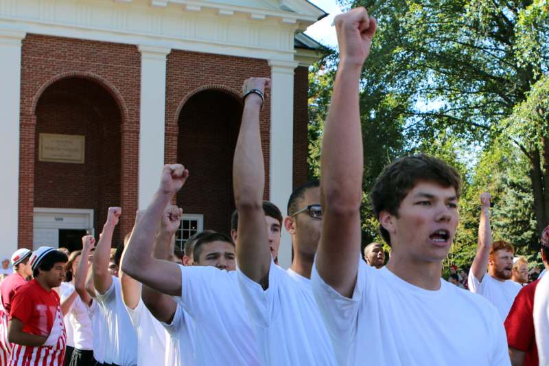 a group of people in white shirts raising their hands