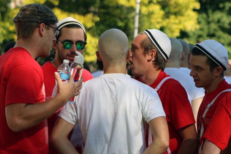 a group of men in red shirts and white caps