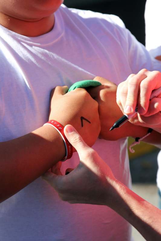 a person signing a signature on a person's arm