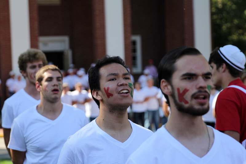 a group of men wearing white shirts with red writing on their faces