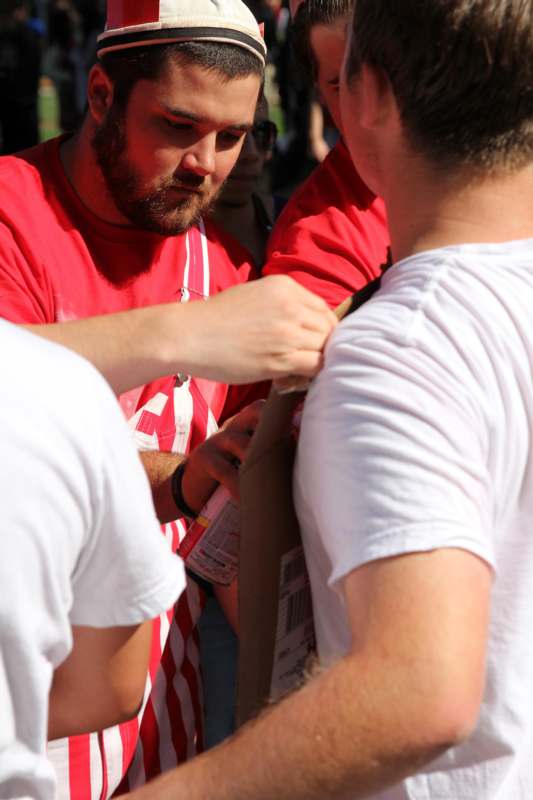 a man signing a sign on a man's shoulder